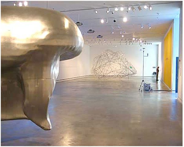 A large metal sculpture in the middle of an empty room.